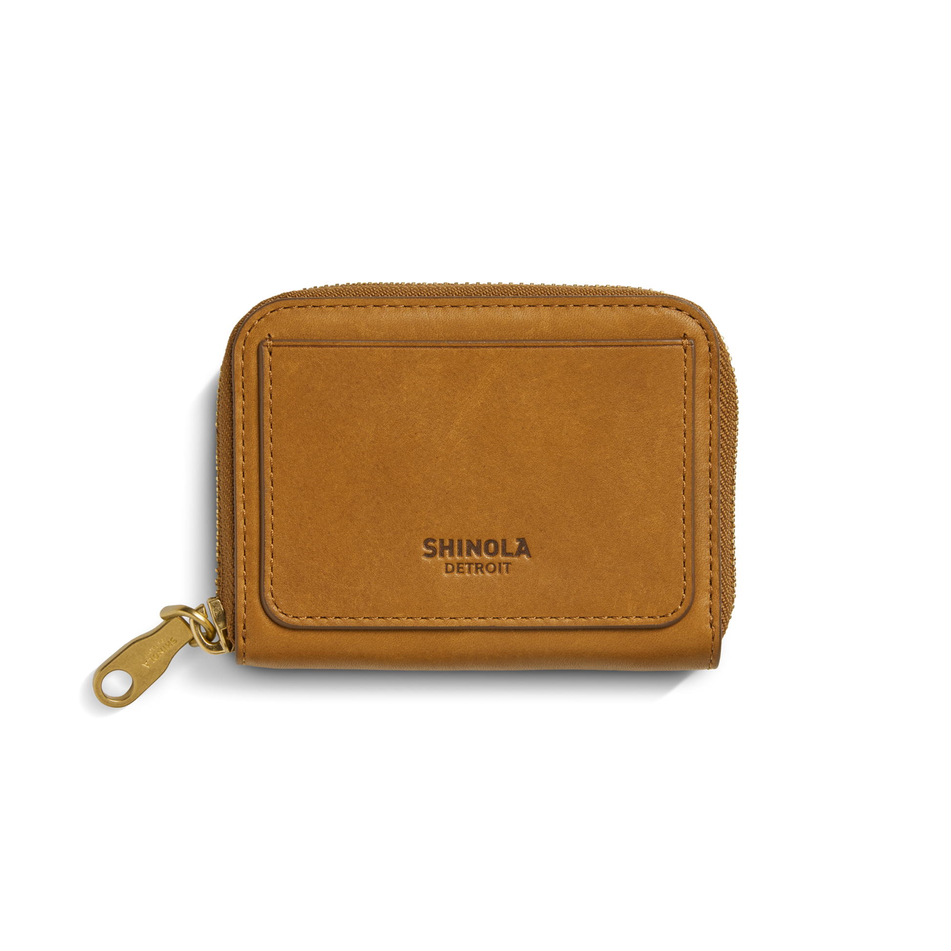 The Shinola Pocket Small Zip Around Wallet in tan natural leather features a gold zipper pull and embossed branding on the front pocket, shown against a white background.