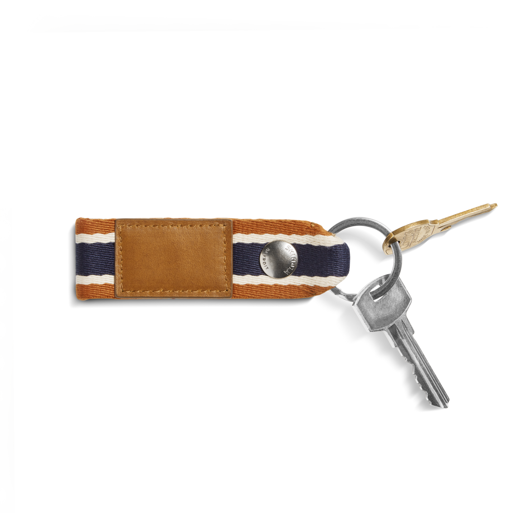 A Shinola Webbing Keychain - Brand Stripe / Tan with a brown leather and striped fabric strap holds two silver keys and one gold key, set against a white background.